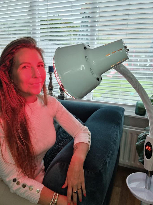 Vrouw gebruikt roodlichttherapie thuis als ondersteunende wellnessroutine