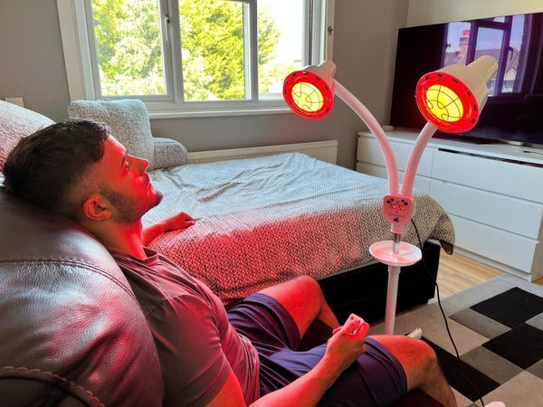 Man ontspant thuis onder een infraroodlamp om stress te verlichten en lichaam en geest tot rust te brengen